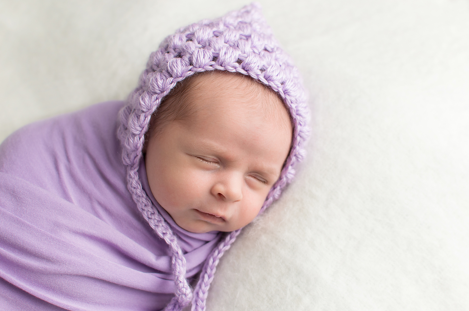 newborn baby wearing a purple bonnet and wrap-simple and clean minimalist-baby pics-photography near middleburg heights ohio.jpg