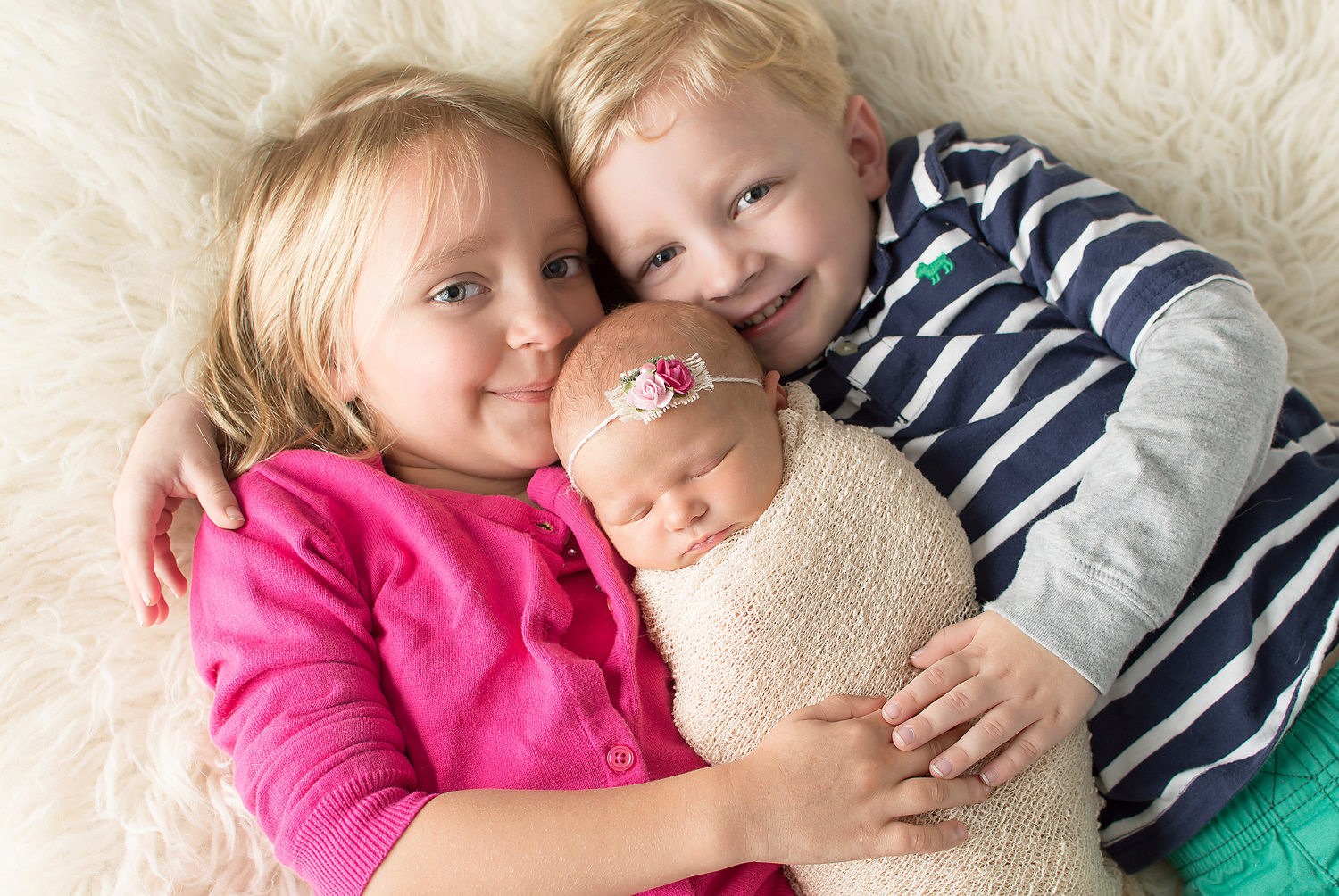 newborn picture with toddler siblings-professional photography near me-simple and colorful-cream fur.jpg